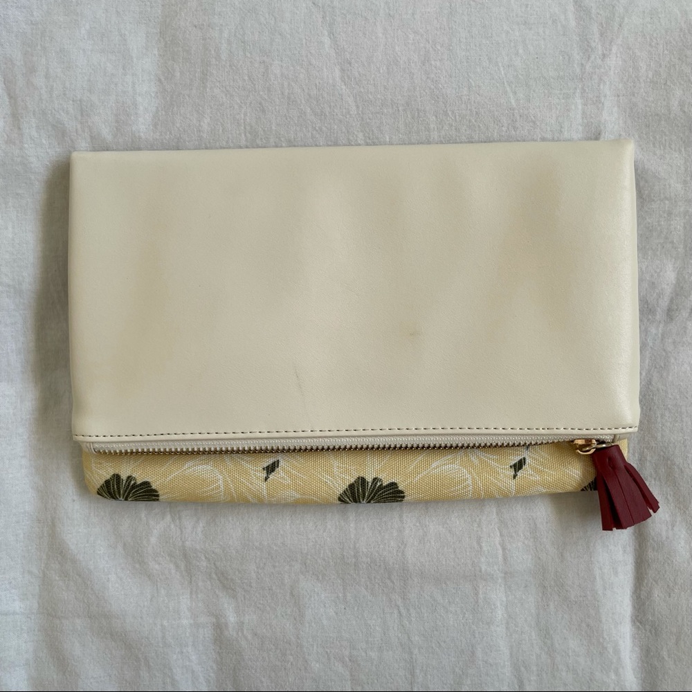 Rachel Pally cream foldover clutch with floral design.